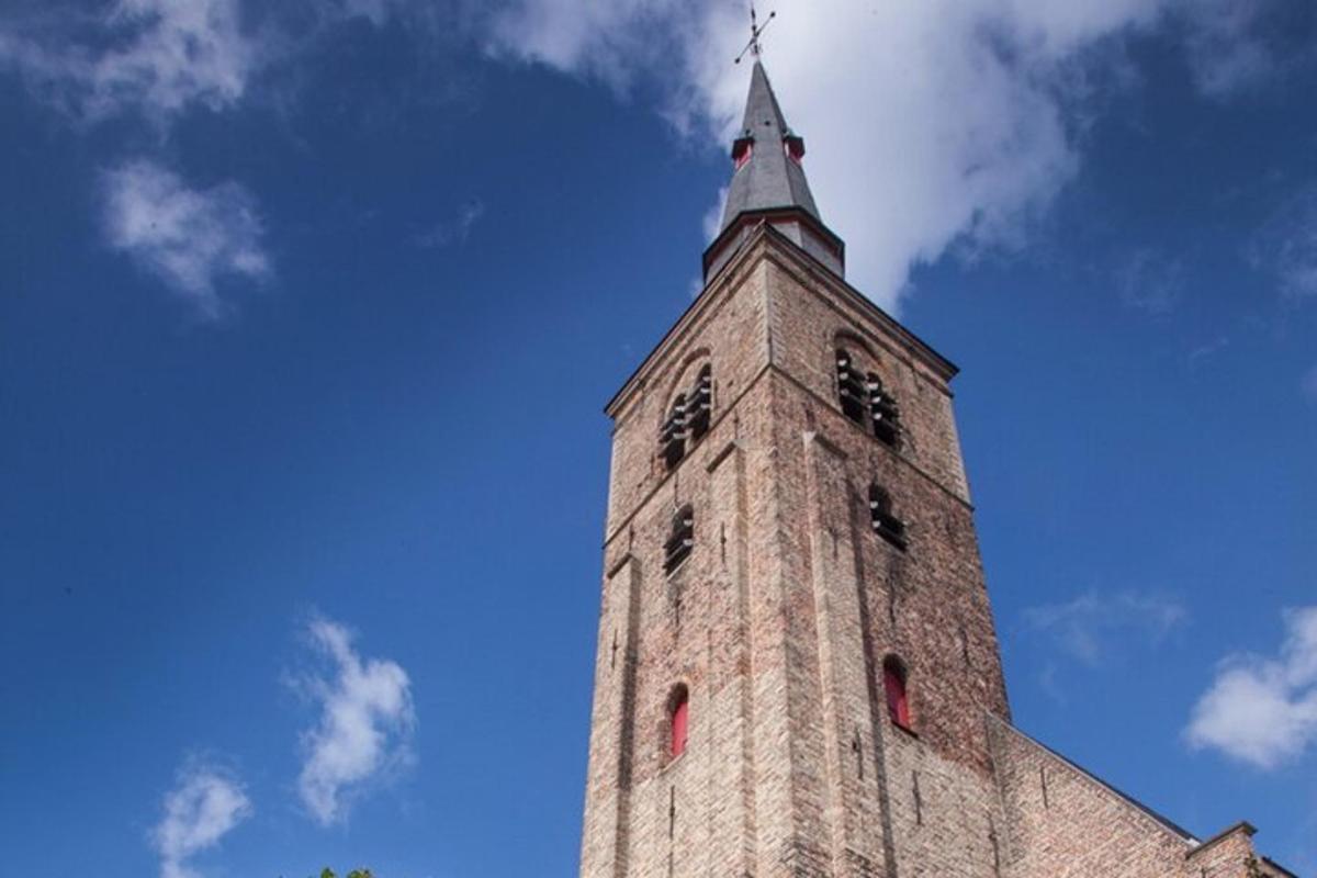 un'alta torre di mattoni con una croce in cima