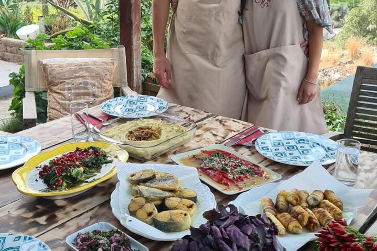 two women standing at a table with food on it