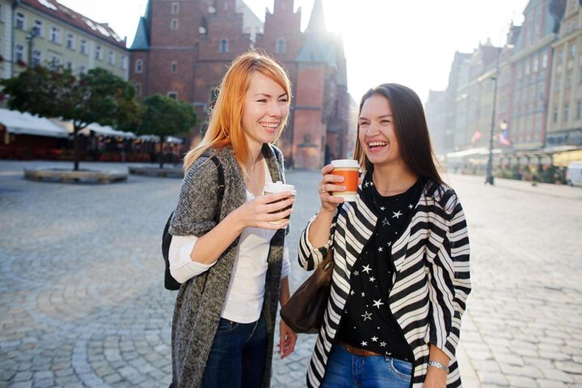 duas jovens em pé uma ao lado da outra segurando bebidas