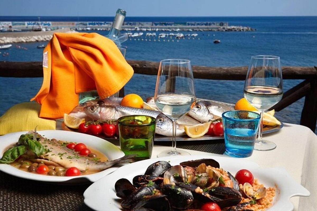 ένα τραπέζι με δύο πιάτα θαλασσινών και ποτήρια κρασιού