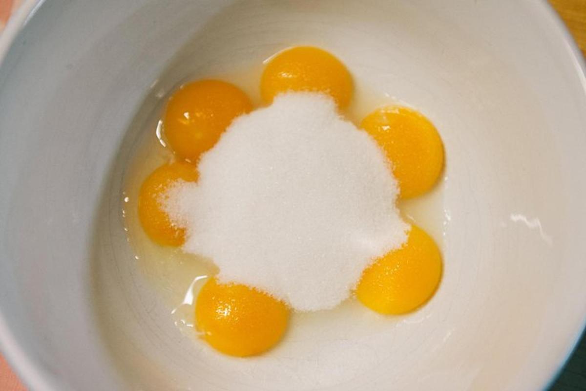 a white bowl filled with eggs and sugar