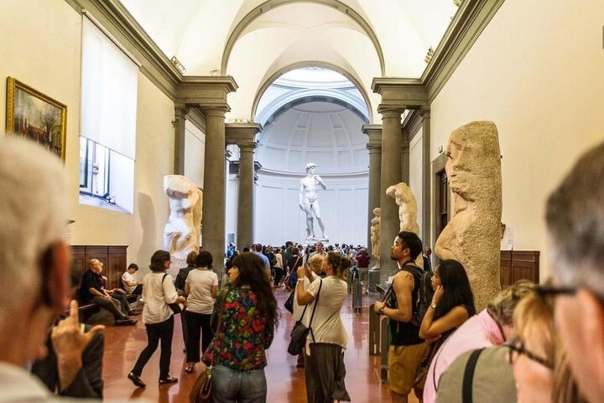 una multitud de gent mirant estàtues en un museu