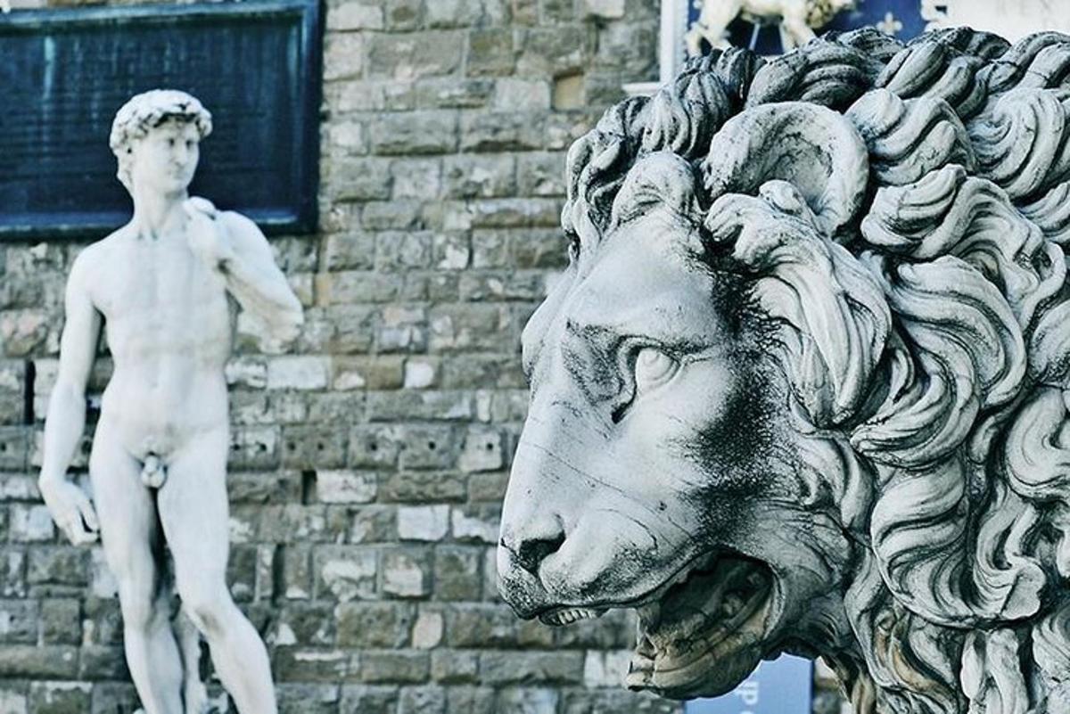 una statua di un leone con un uomo su una testa di leone