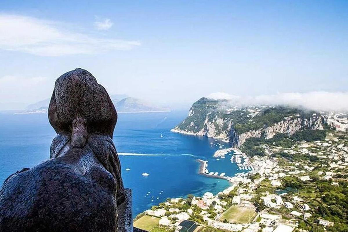una statua in cima a una montagna che domina l'oceano