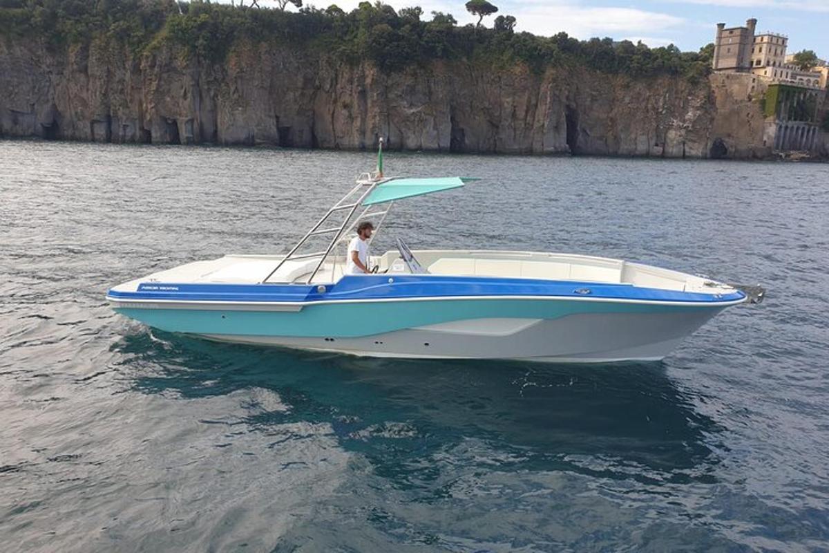 isang lalaki sa isang asul at puting bangka sa tubig