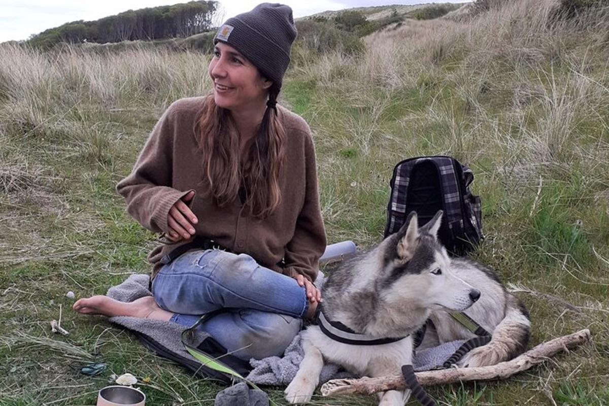 una donna seduta a terra con il suo cane