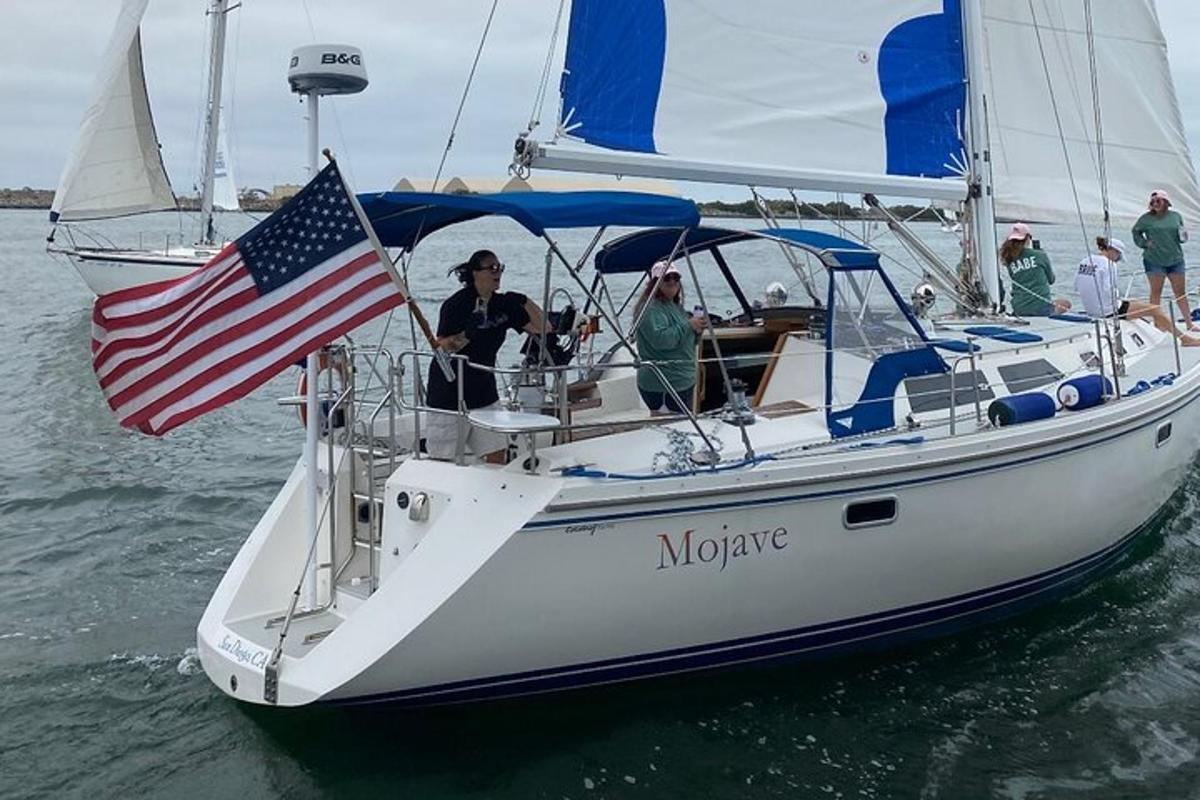 un gruppo di persone su una barca a vela con una bandiera americana