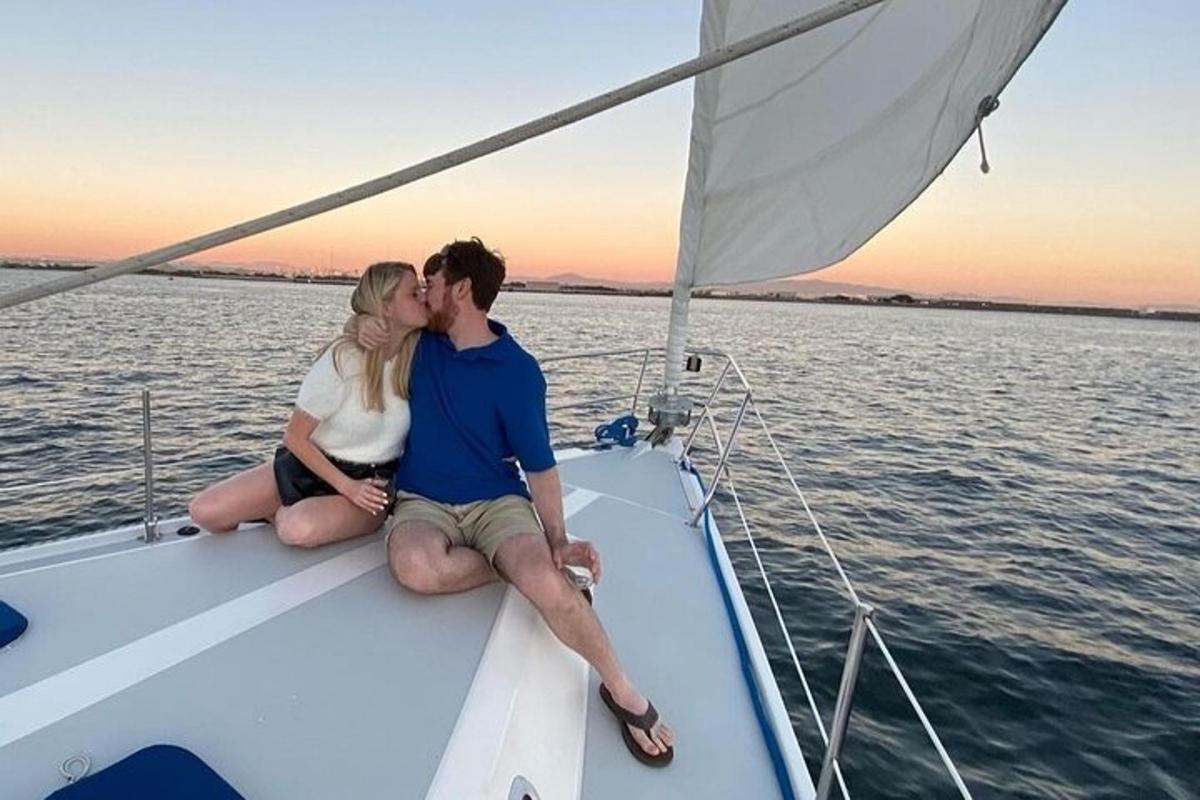 un uomo e una donna che si baciano su una barca a vela