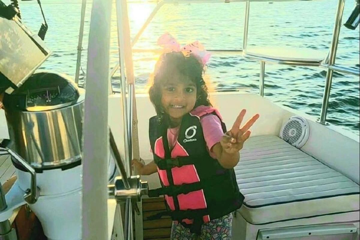 una bambina con un giubbotto di salvataggio su una barca