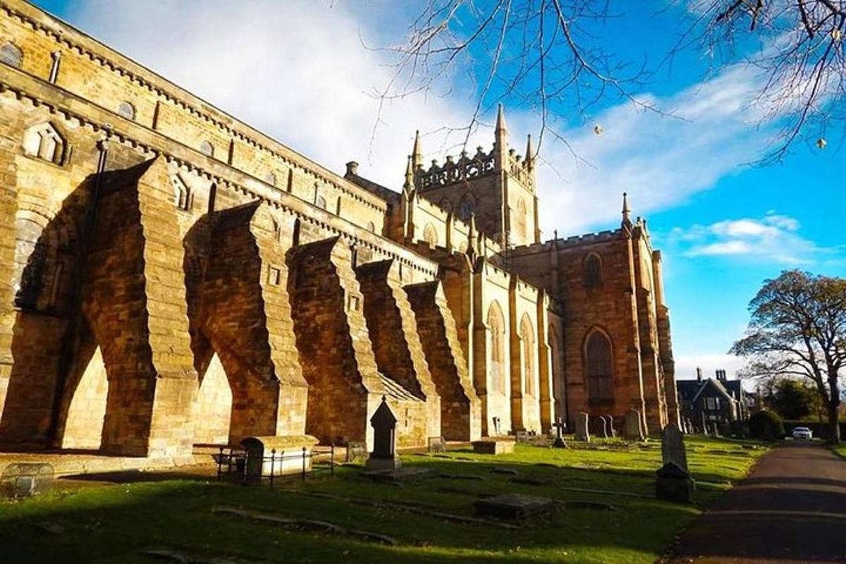 un grande edificio in mattoni con una chiesa sullo sfondo