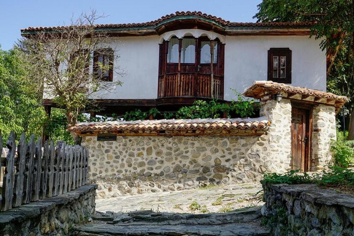 una casa con un muro di pietra e una recinzione