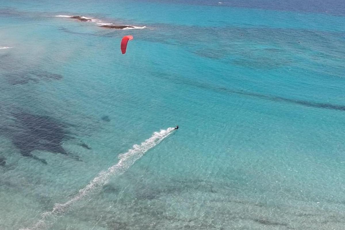 a person is flying a kite in the ocean
