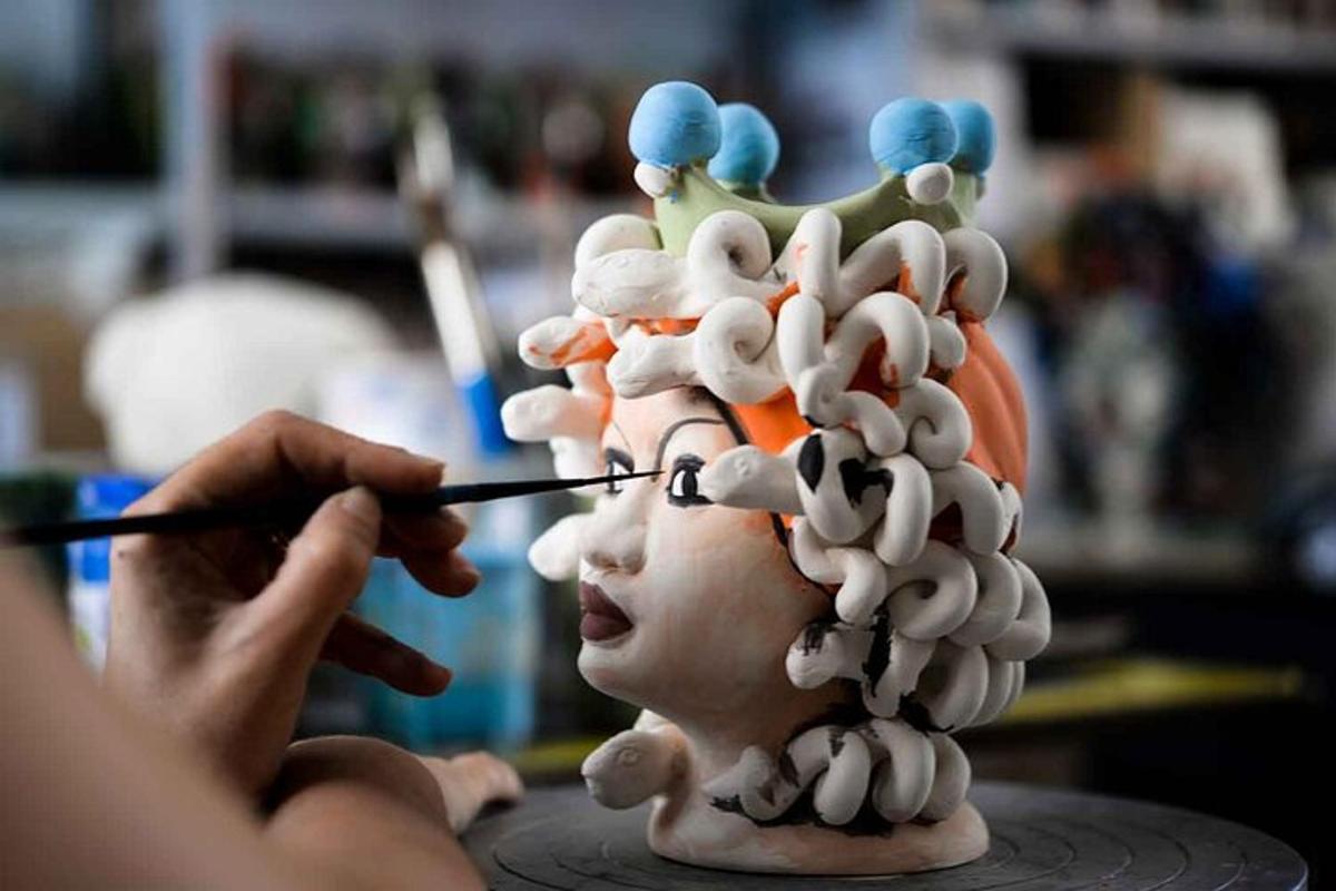 ein Mann, dessen Kopf mit einem Haarschmuck modelliert wird