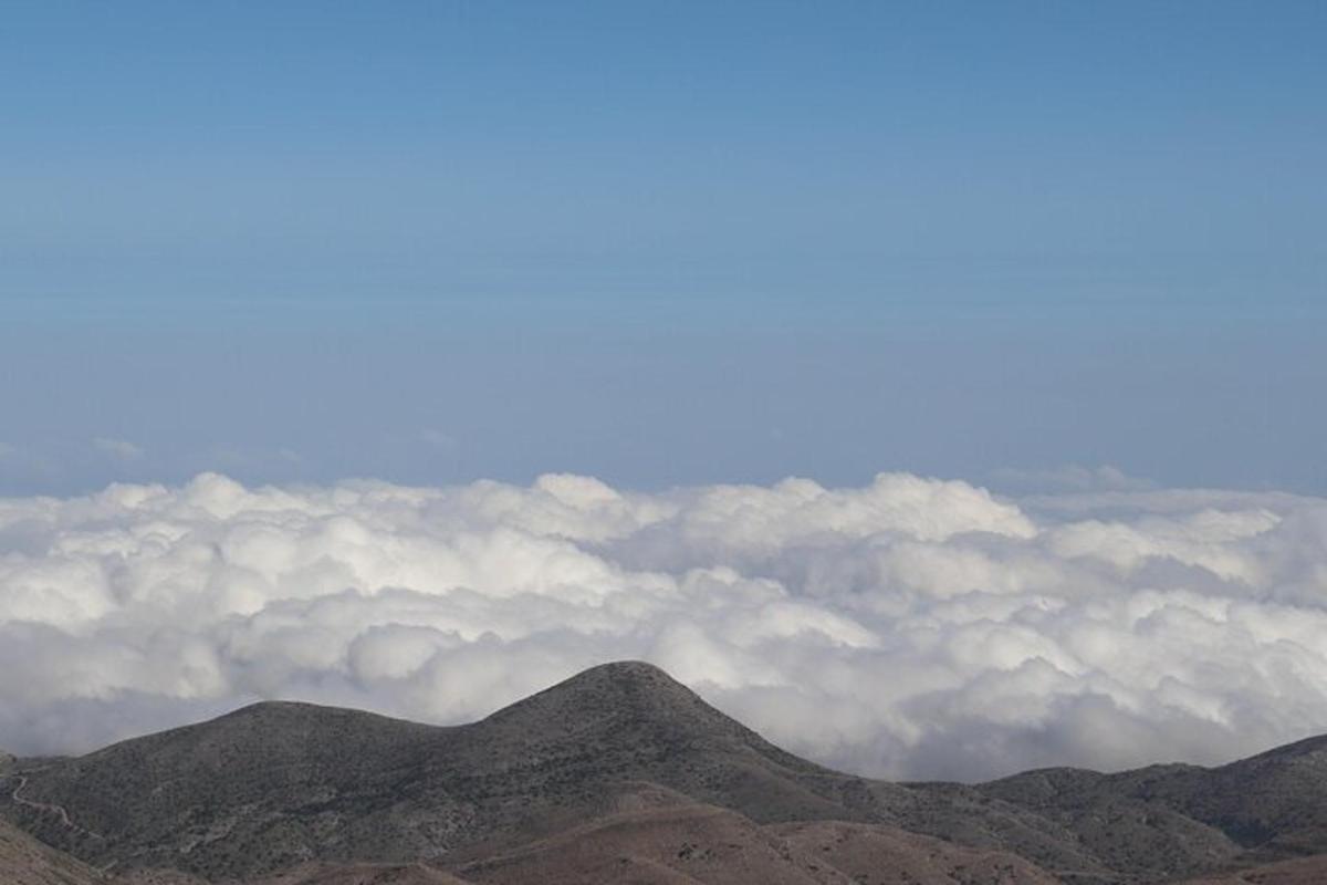 sekumpulan gunung dengan awan di latar belakang