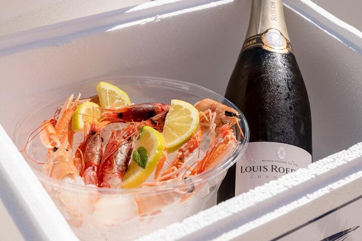 a plastic container of shrimp and lemons and a bottle of champagne