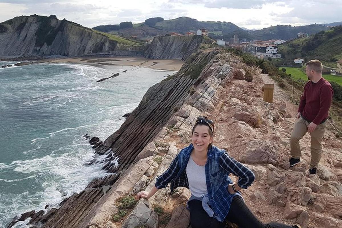 žena sedící na útesu u oceánu