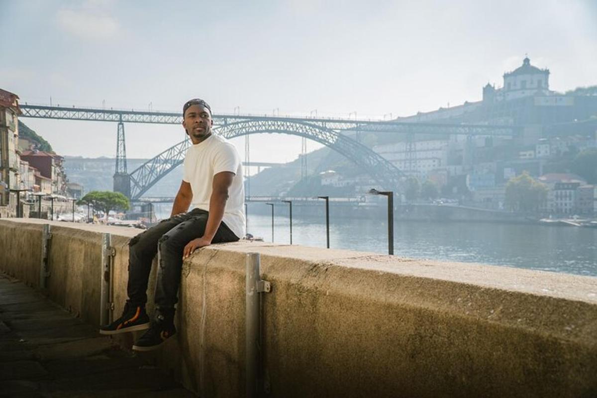 a man sitting on a wall next to the water