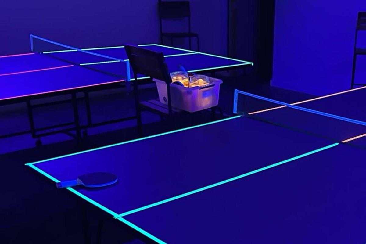 meja ping pong dalam bilik dengan lampu ungu