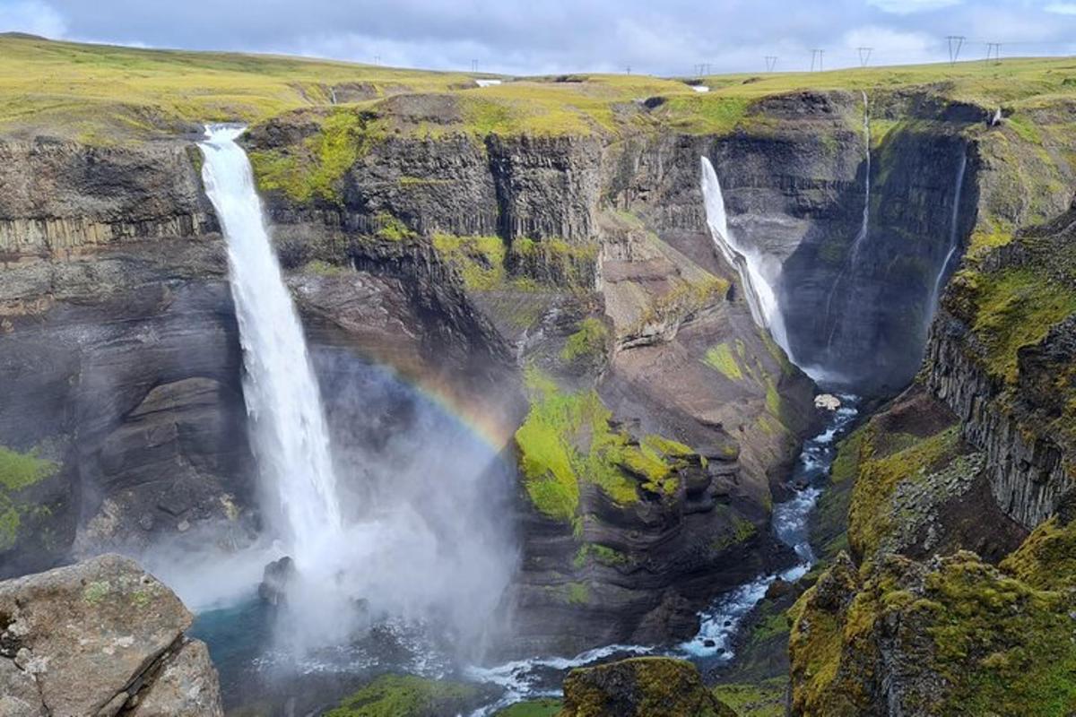 un arcobaleno sopra una cascata su una scogliera