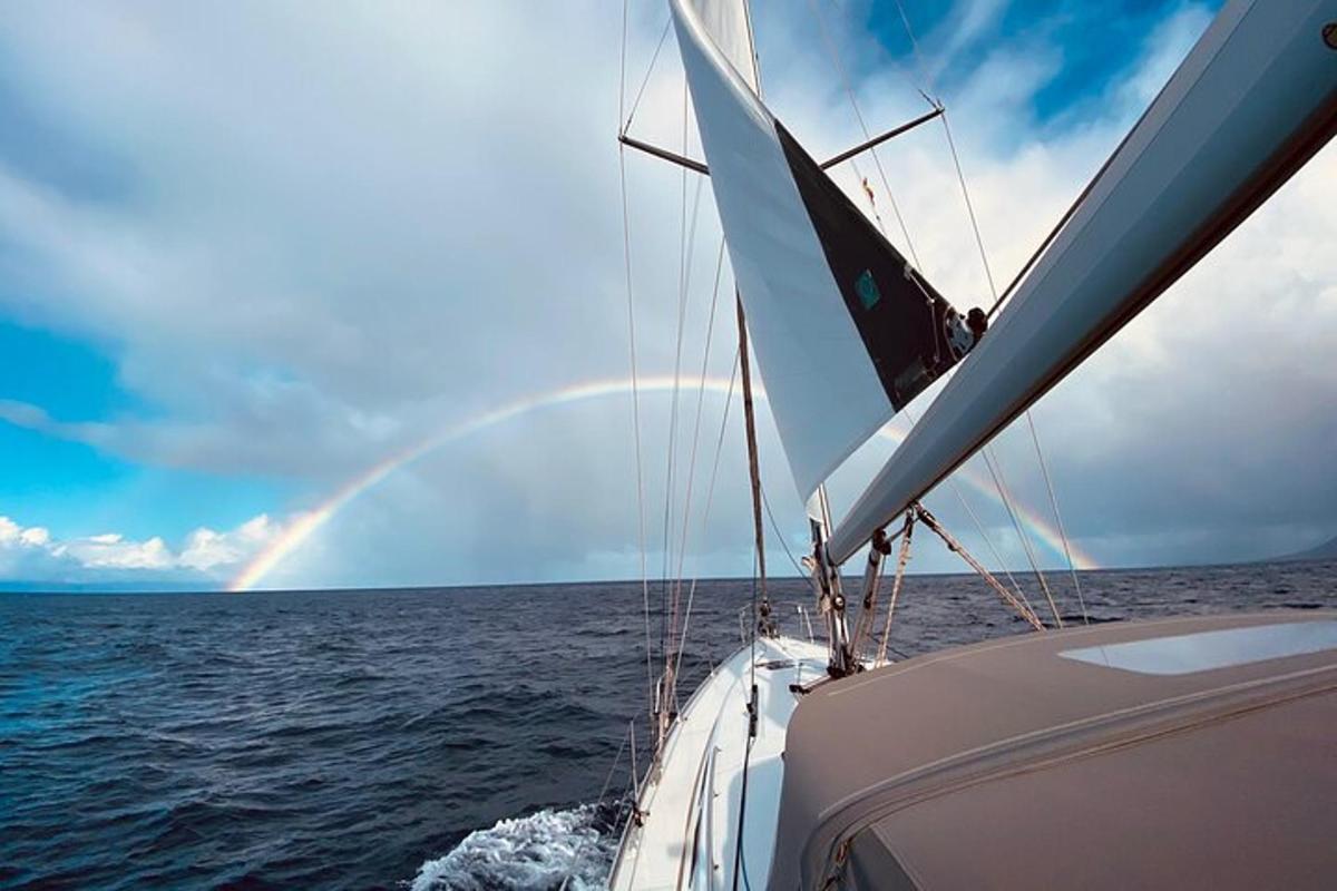 a boat in the ocean with a rainbow in the sky