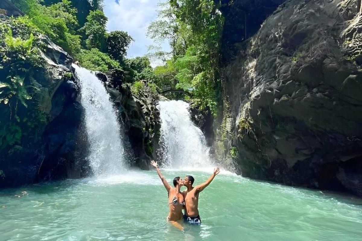 twee mensen in het water voor een waterval