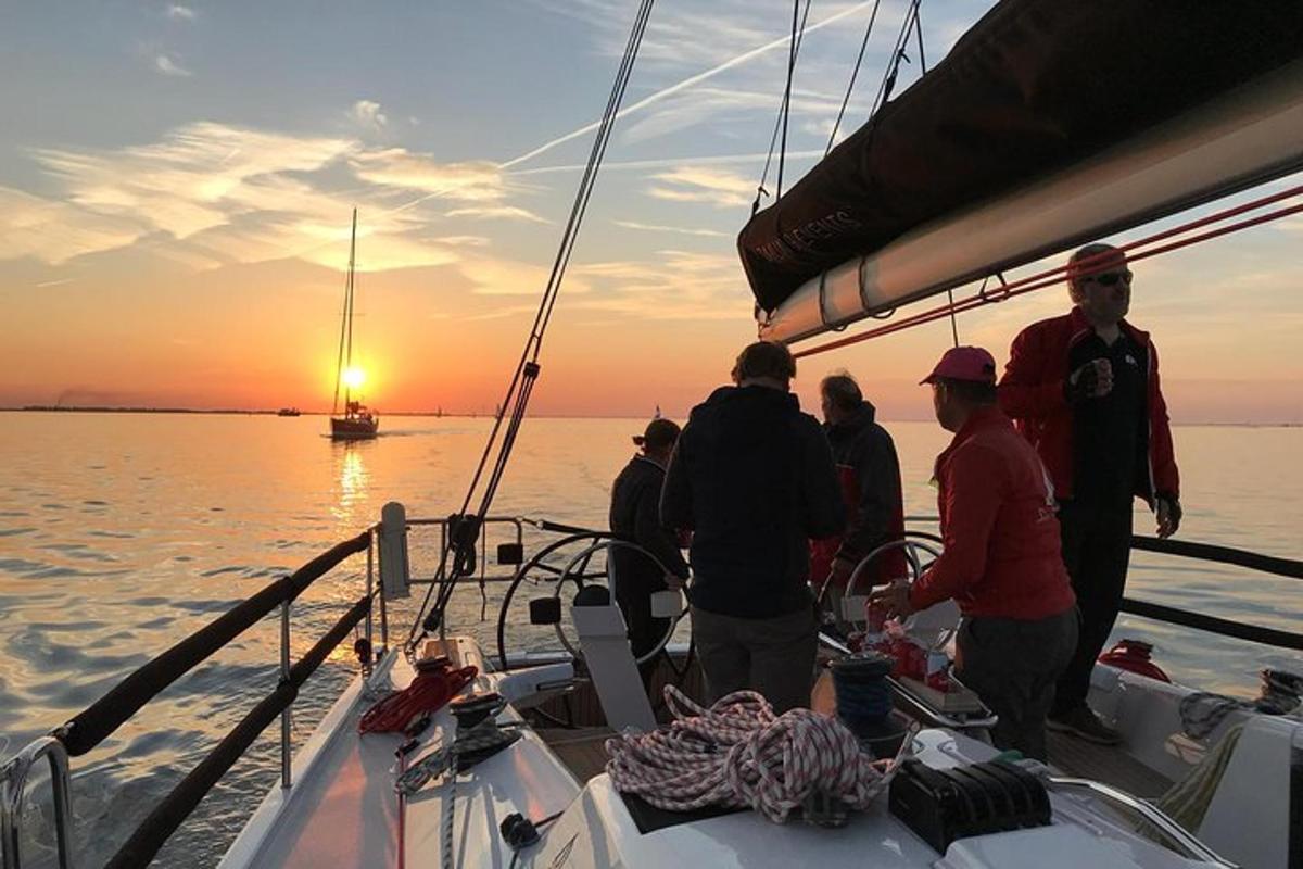 un gruppo di persone in piedi su una barca al tramonto