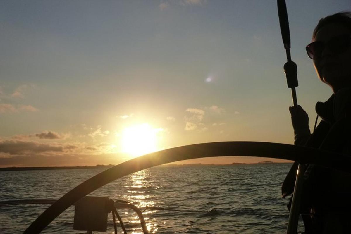 una donna su una barca che guarda il tramonto