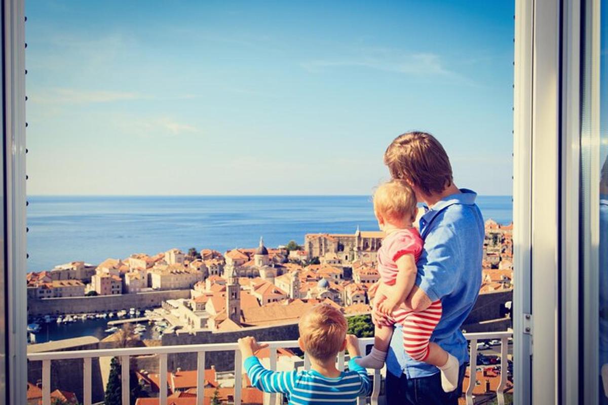 a man and two children standing on a balcony looking at a city