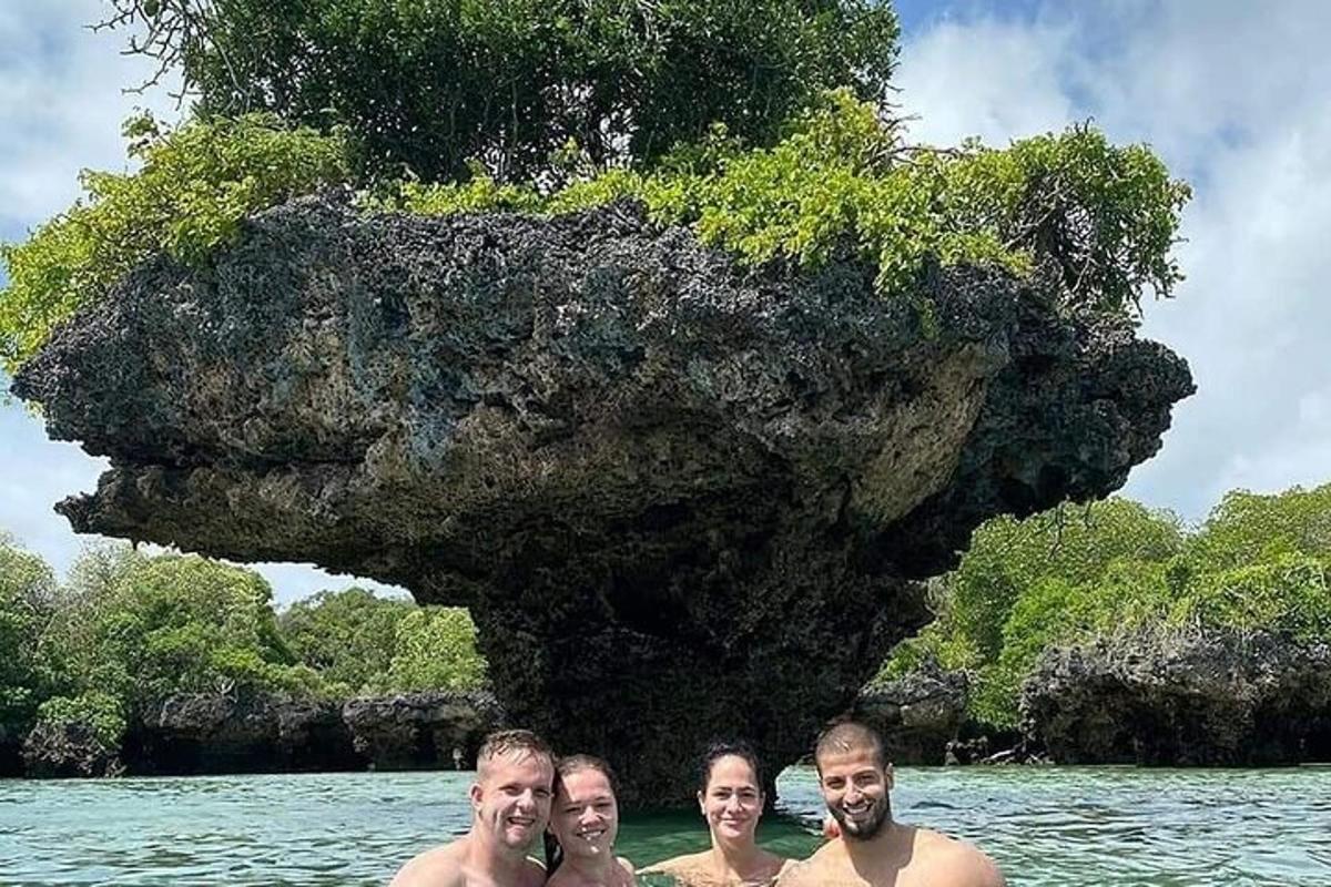 empat orang berdiri di dalam air di hadapan sebuah pulau
