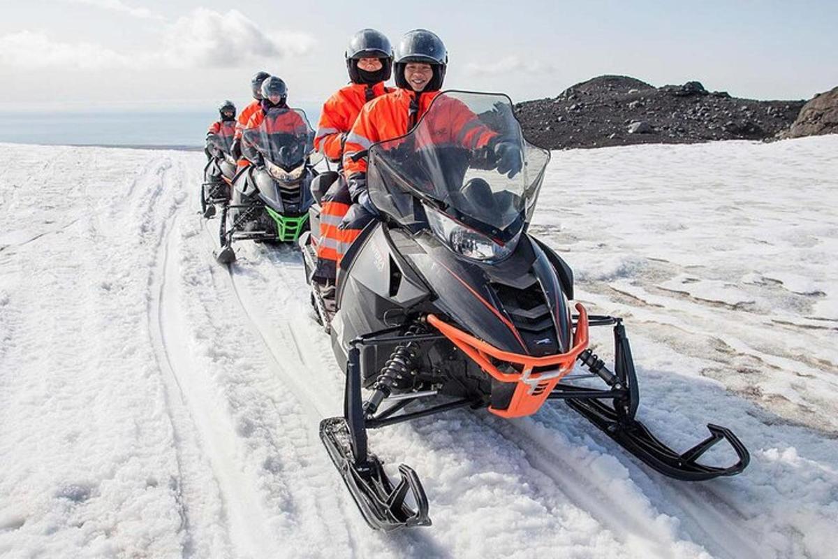 en gruppe mennesker som kjører motorsykler i snøen