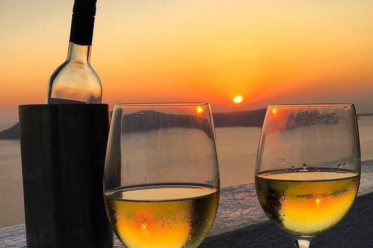 two glasses of wine sitting on a table with a bottle of wine