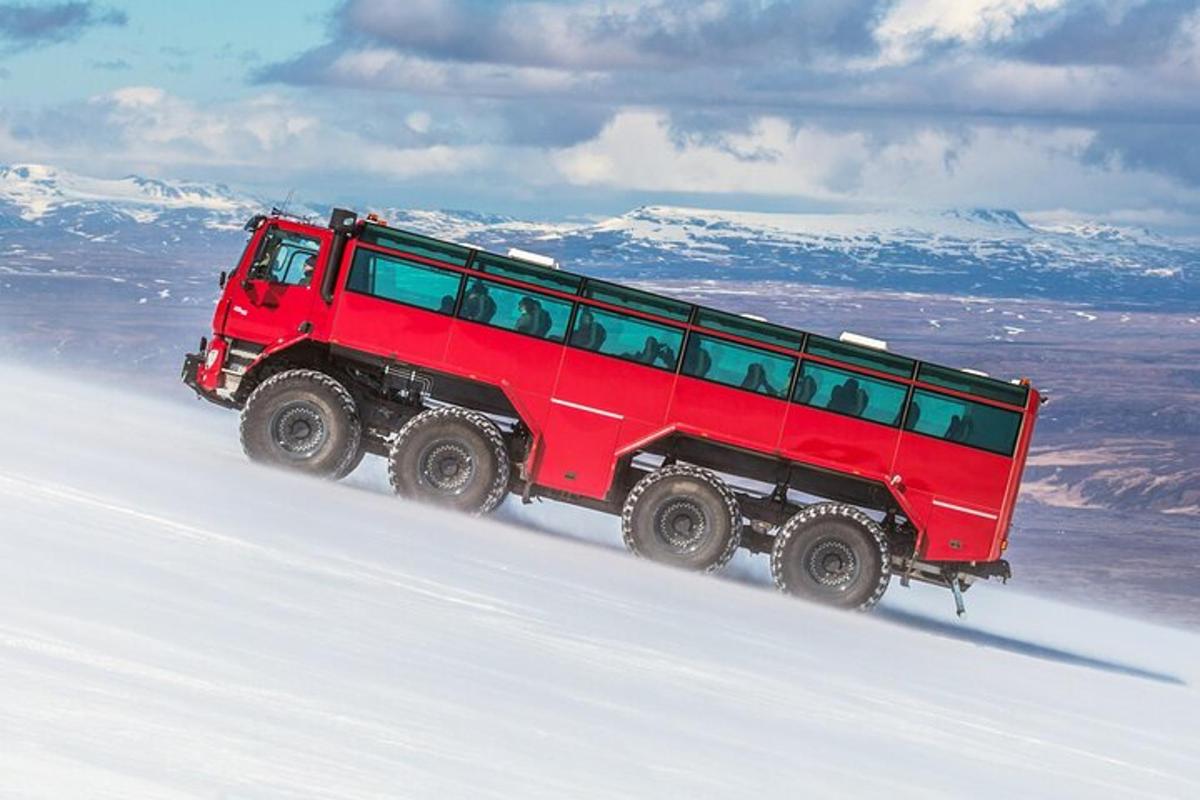 una jeep rossa che scende da una montagna innevata