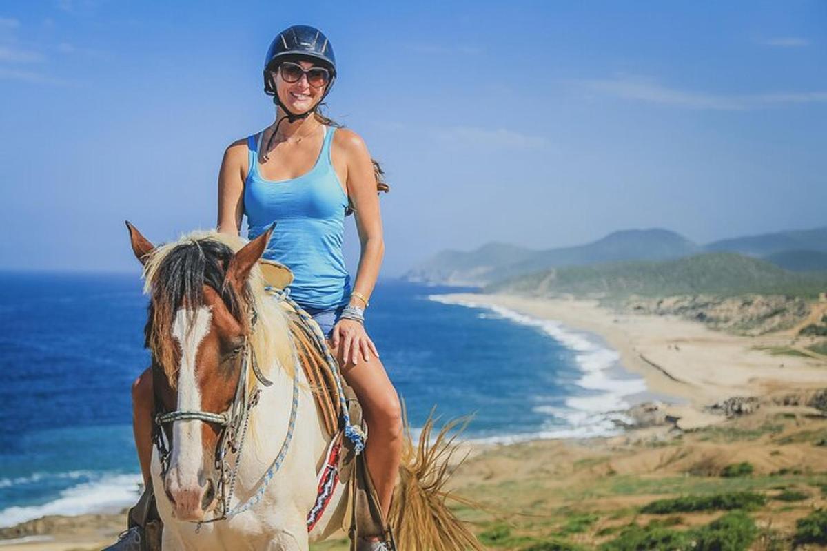 a woman riding a horse on the beach