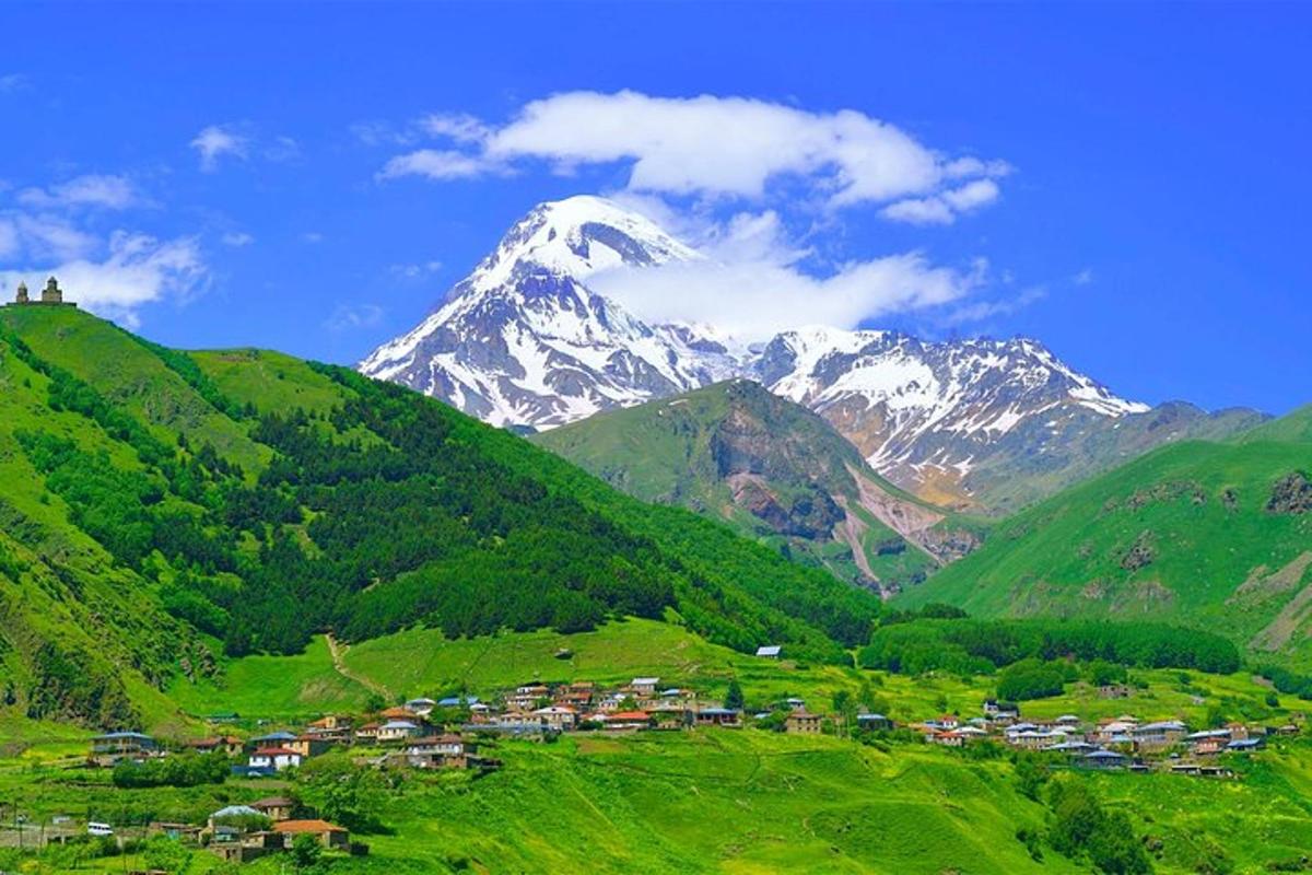 a mountain with a village in a green valley