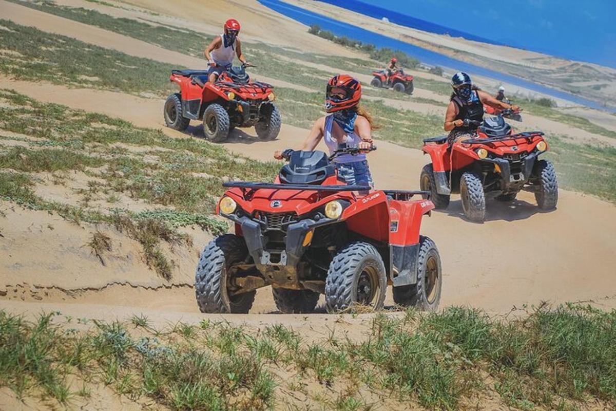 a group of people riding atvs on the beach