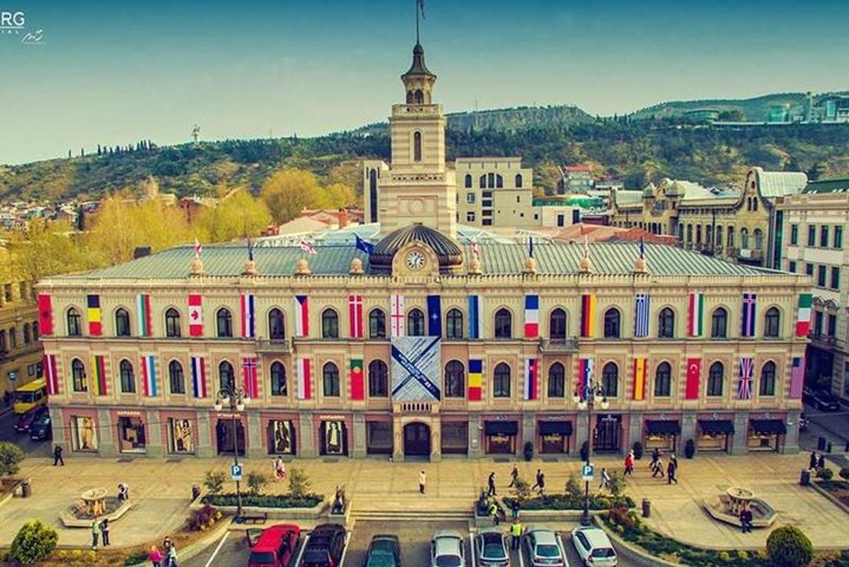un grande edificio con auto parcheggiate di fronte