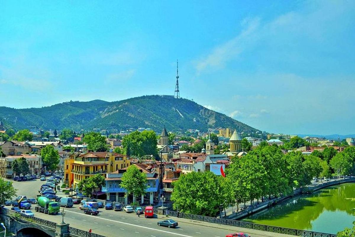 una città con auto parcheggiate su una strada accanto a un fiume