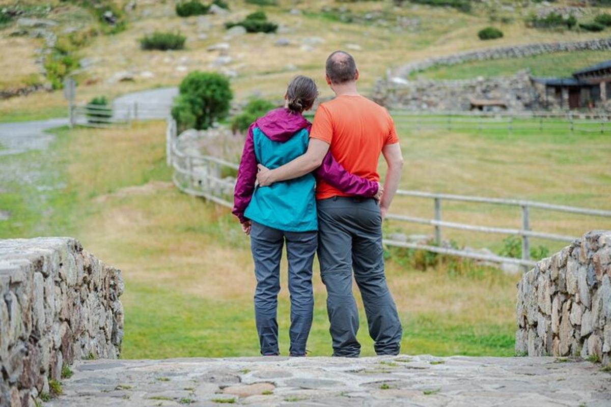 Maður og kona standa á brú og horfa á akur