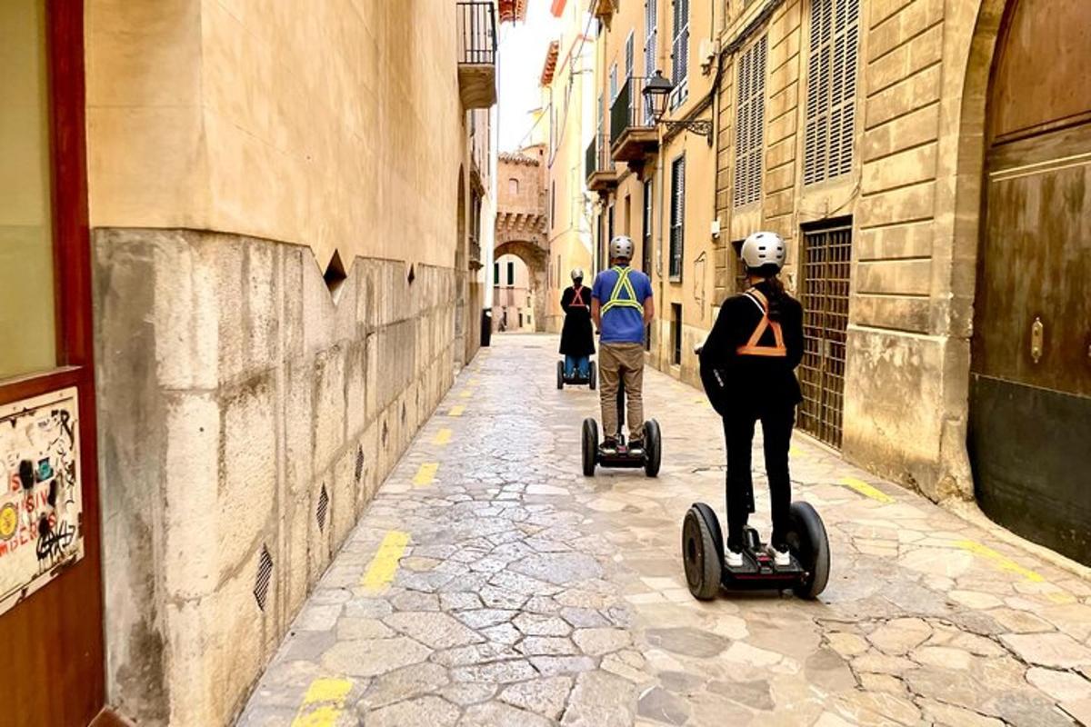 dva lidé jedoucí na segwayích po ulici