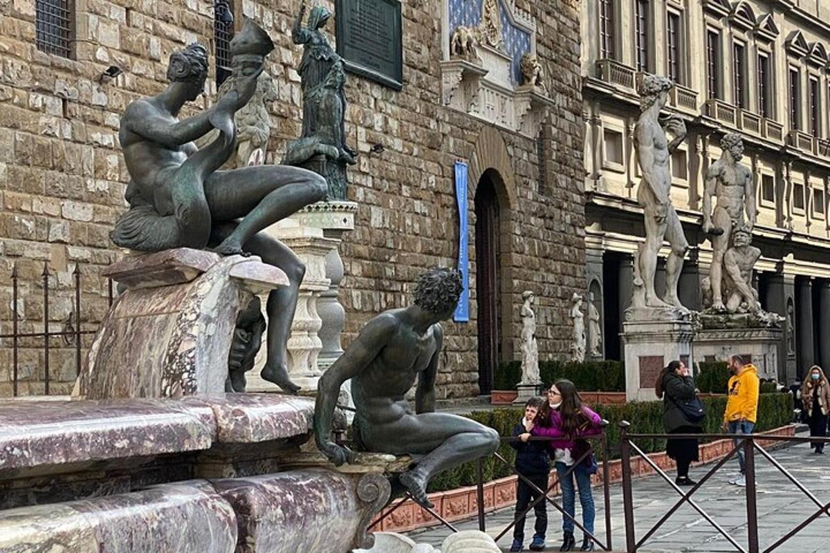 moteris fotografuoja statulą priešais fontaną