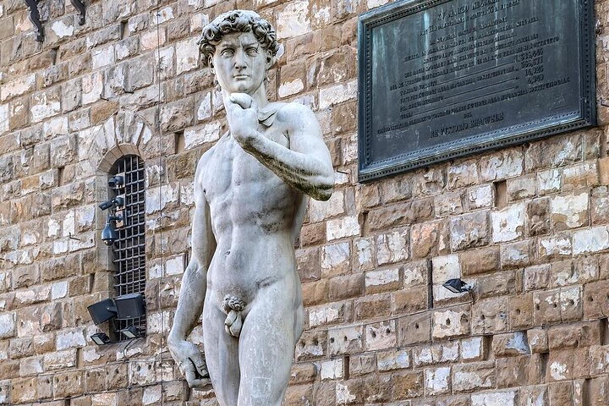 o statuie a unui bărbat care stă lângă o clădire din cărămidă