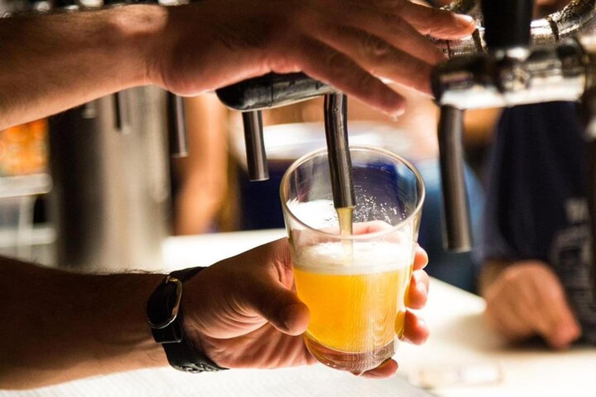 een persoon houdt een glas bier vast