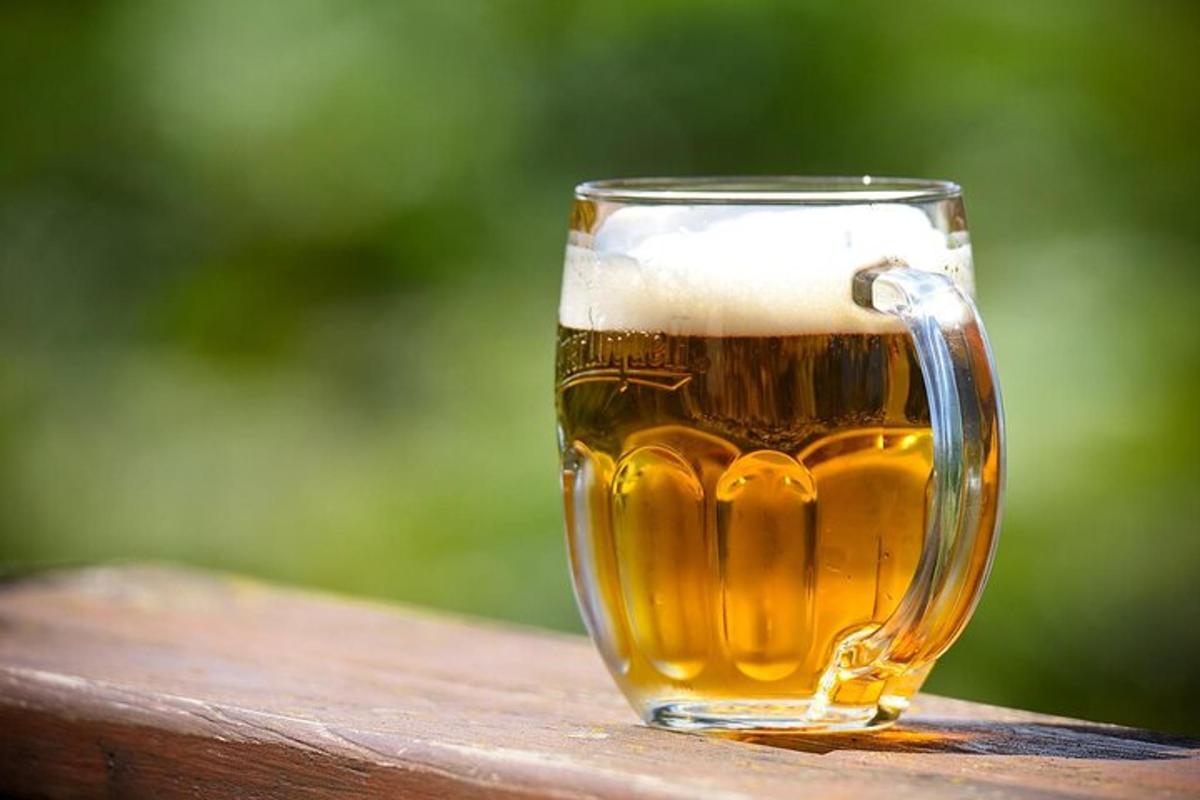 un got de cervesa assegut sobre una barana de fusta