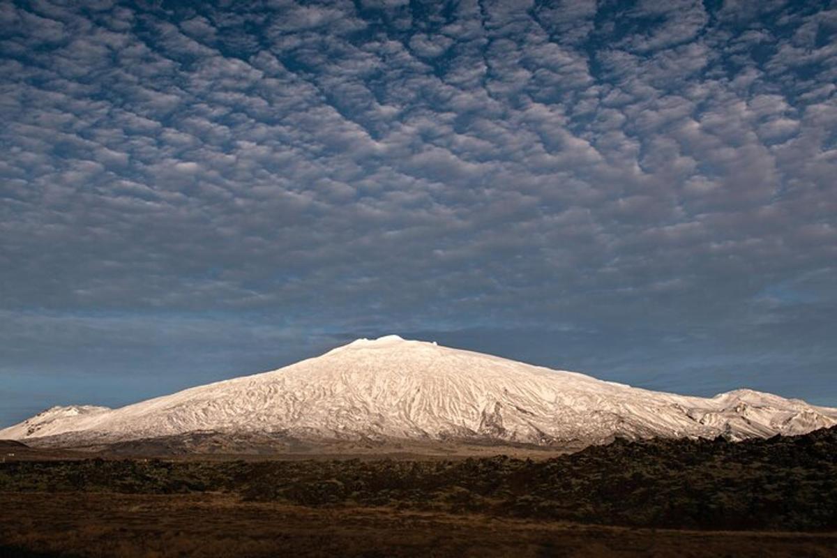 una montaña cubierta de nieve bajo un cielo nublado