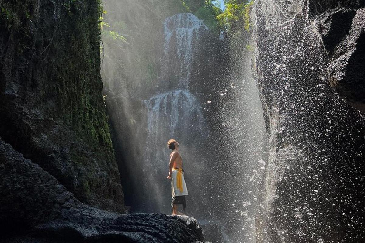 maður stendur fyrir framan foss