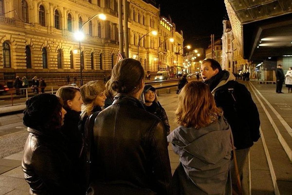 un grup de persones dempeus en un carrer a la nit