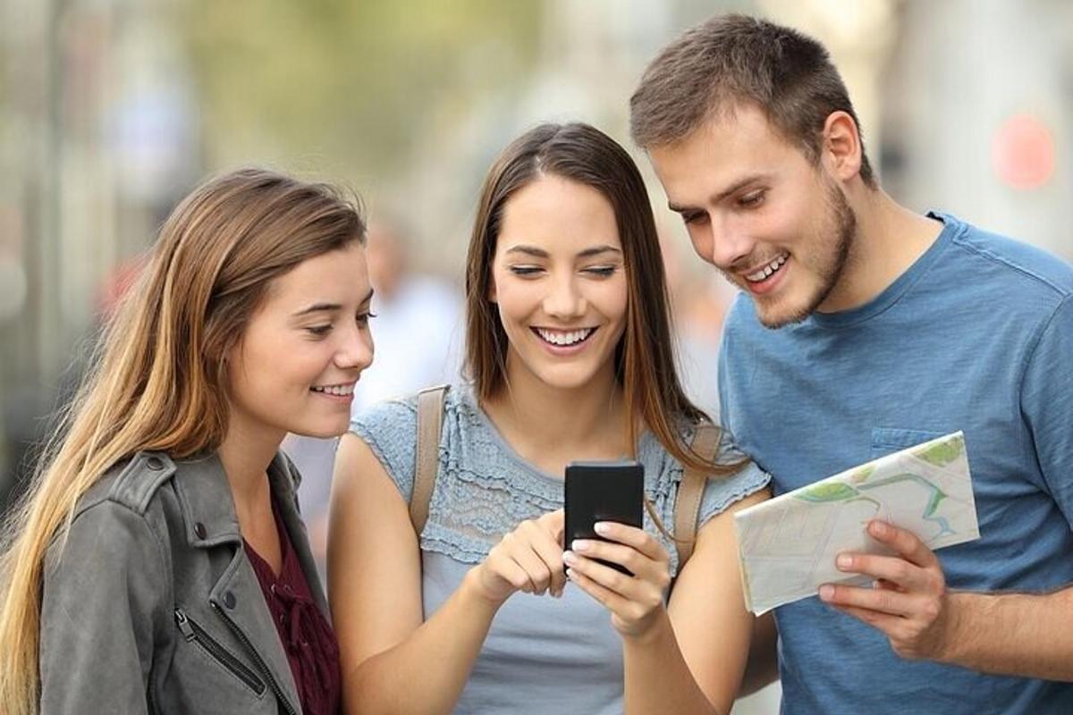 un gruppo di tre persone che guardano un telefono cellulare