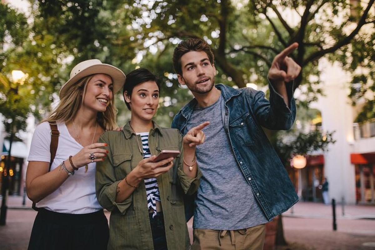 skupina tří lidí dívajících se na mobilní telefon