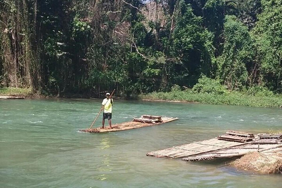 um homem está em pé em uma jangada em um rio