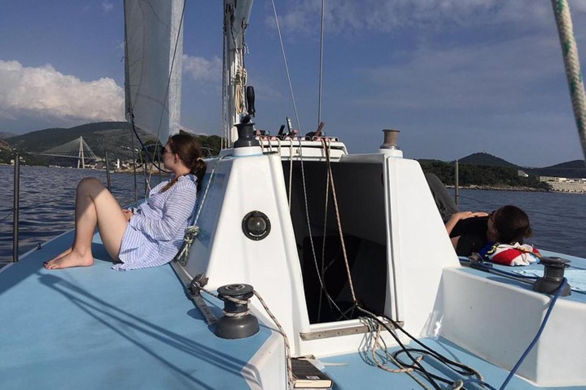 una dona asseguda en un veler a l'aigua